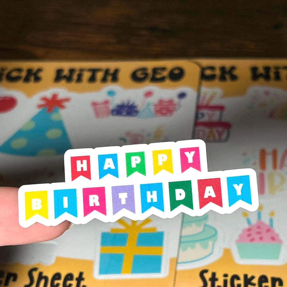 Sheet of birthday-themed stickers with colorful text and graphics on a wooden surface.