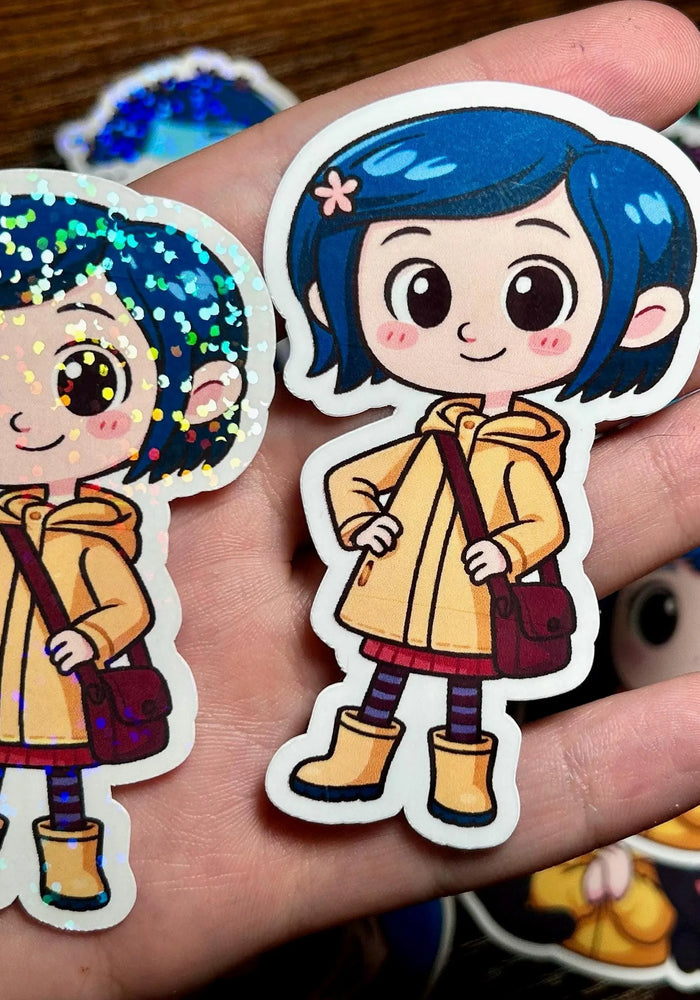 Two stickers of a character with blue hair and a yellow raincoat held in a hand.