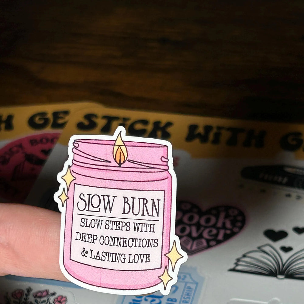 Pink jar sticker with 'Slow Burn' text held over a book club card.