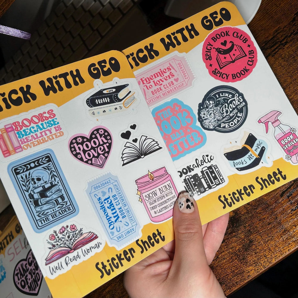 Sticker sheet with various designs held by a hand on a wooden surface
