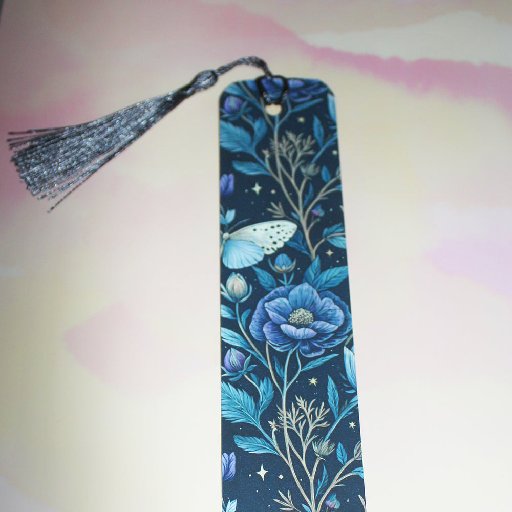 Decorative bookmark with blue floral design and tassel on a colorful background