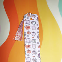 Load image into Gallery viewer, Decorative bookmark with tassel on a colorful abstract background
