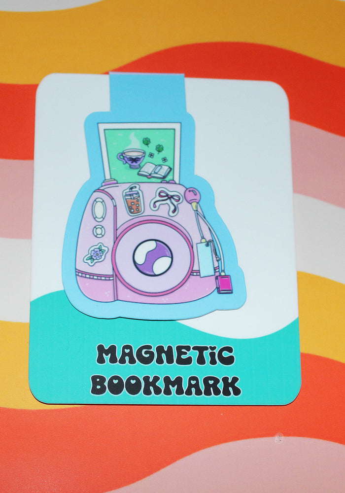 Magnetic bookmark with a pink camera design on a colorful striped background