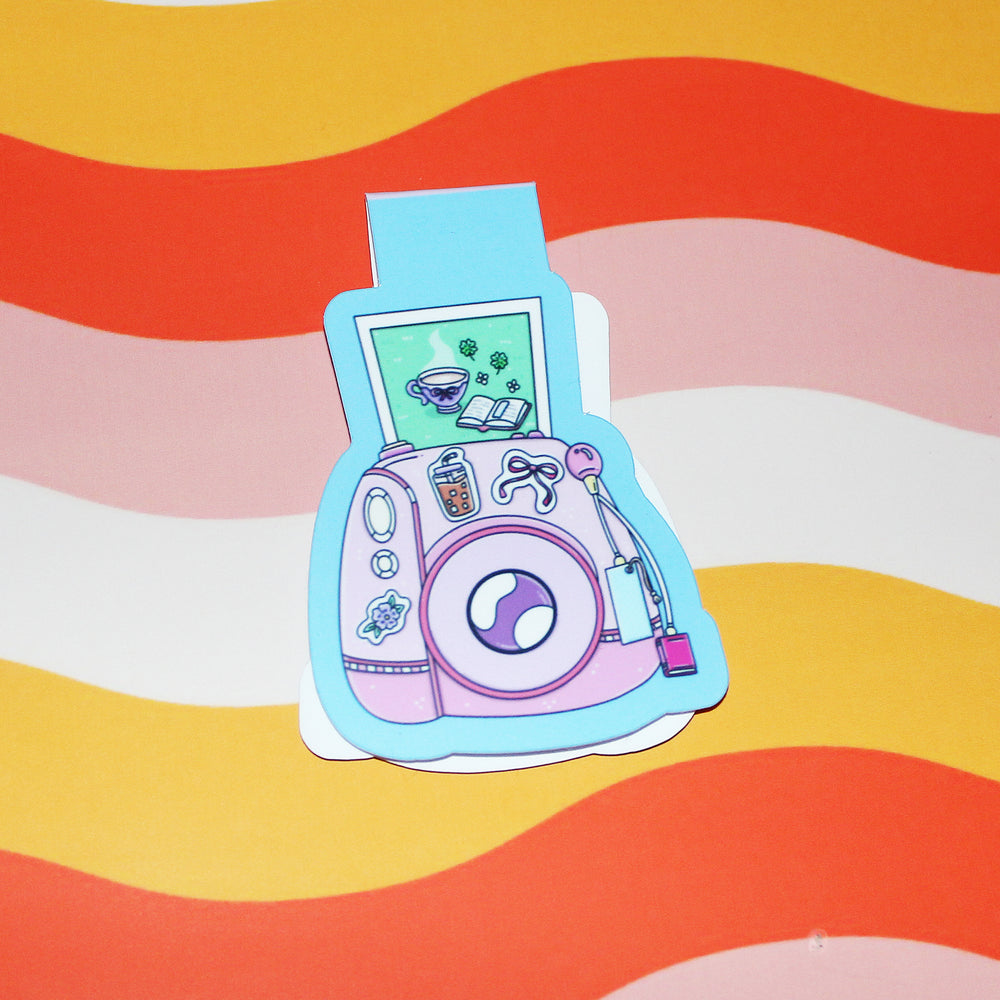 Colourful camera-shaped bookmark on a wavy striped background