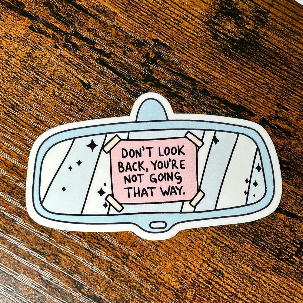 Sticker with motivational quote on a wooden surface
