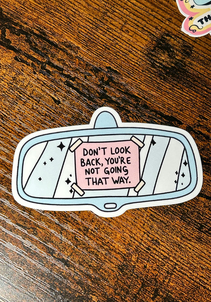 Sticker with motivational quote on a wooden surface