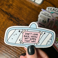 Load image into Gallery viewer, Sticker with motivational quote held by a hand on a wooden surface
