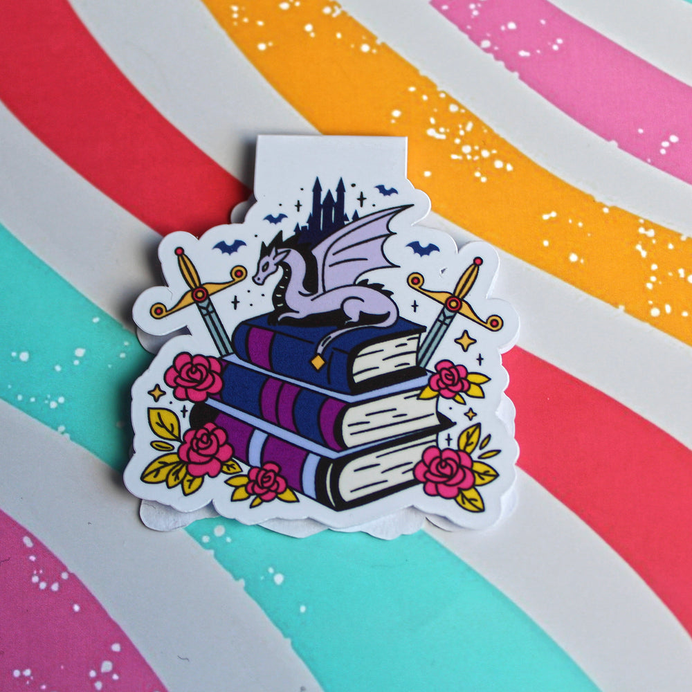 Magnetic Bookmark with a dragon on books against a colourful striped background