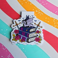 Load image into Gallery viewer, Magnetic Bookmark with a dragon on books against a colourful striped background
