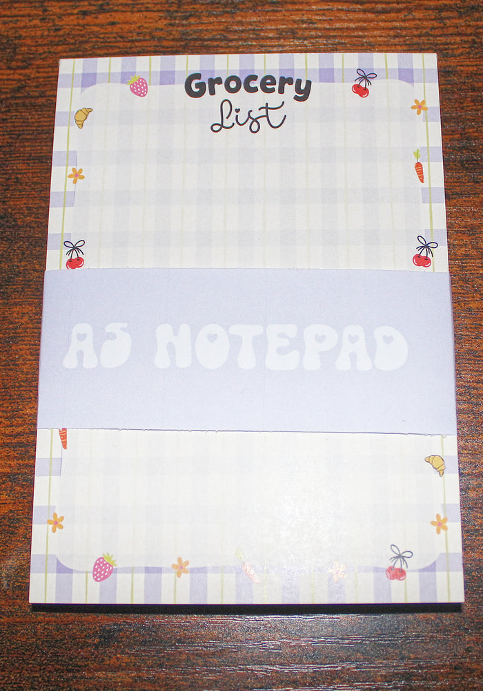 Notepad with 'Grocery List' on a wooden surface