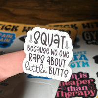 Load image into Gallery viewer, Sticker with text 'Squat because no one raps about little butts' held by a hand.
