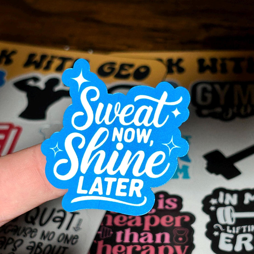 Blue sticker with 'Sweat Now, Shine Later' text held over a background with other stickers.