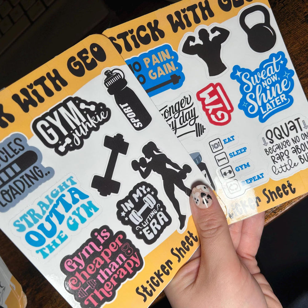 Sheet of gym-themed stickers held by a hand with a wooden surface in the background