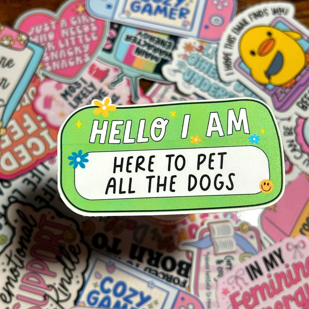 Sticker with 'HELLO I AM HERE TO PET ALL THE DOGS' text on a colourful background of other stickers.