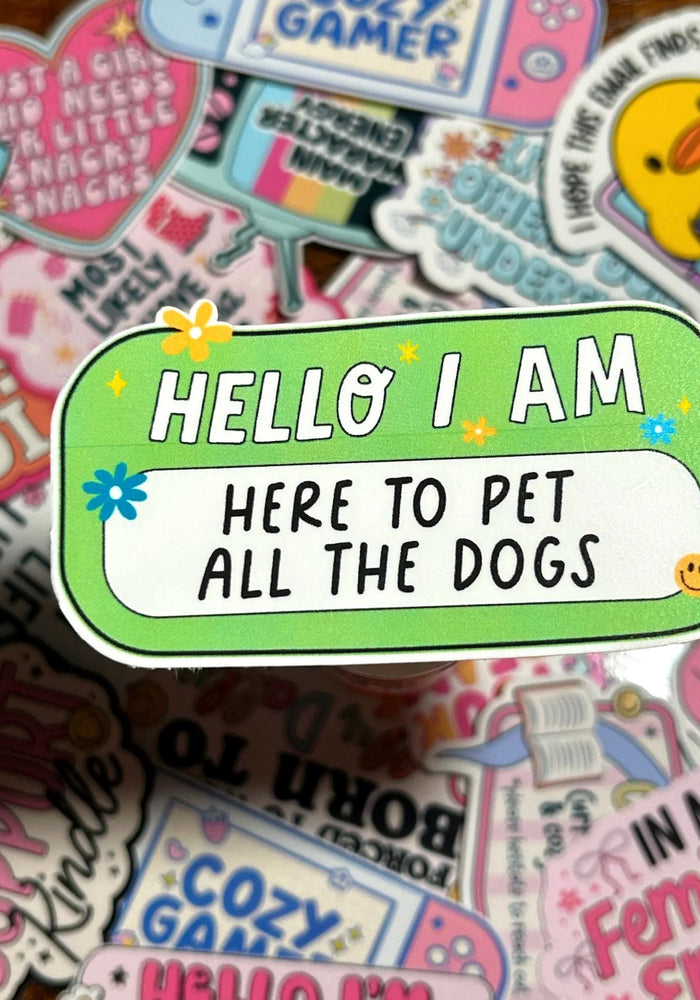 Sticker with 'HELLO I AM HERE TO PET ALL THE DOGS' text on a colourful background of other stickers.