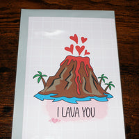 Load image into Gallery viewer, Card with a volcano illustration and 'I LAVA YOU' text on a wooden surface
