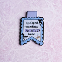 Load image into Gallery viewer, Enamel pin with text 'I stopped reading FANTASY here' on a light purple background

