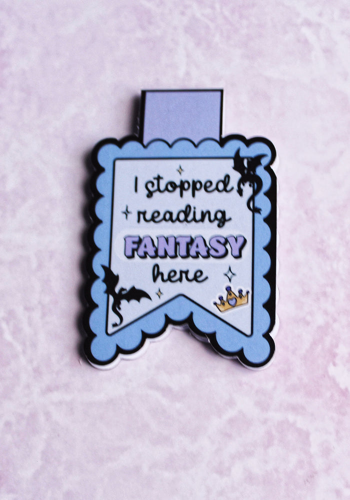 Enamel pin with text 'I stopped reading FANTASY here' on a light purple background
