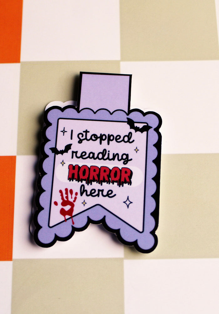 Magnetic bookmark with text 'I stopped reading horror here' on a checkered background