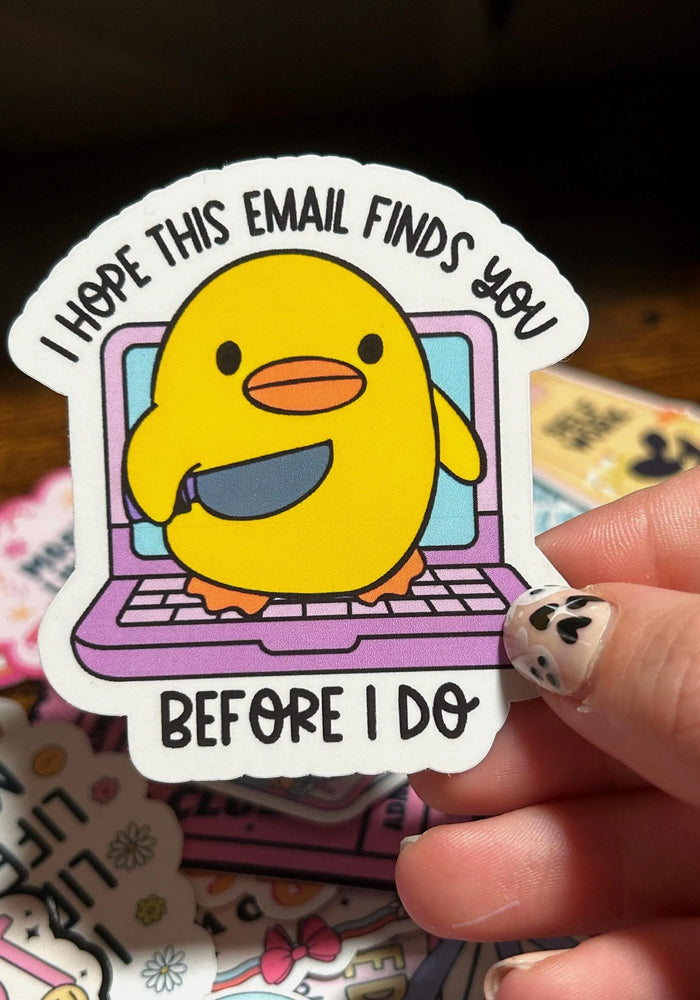 Sticker with a yellow duck on a laptop and text 'I hope this email finds you before i do' held by a hand