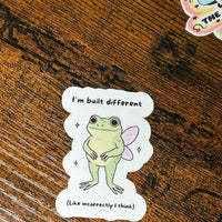Load image into Gallery viewer, Sticker of a frog with fairy wings on a wooden surface
