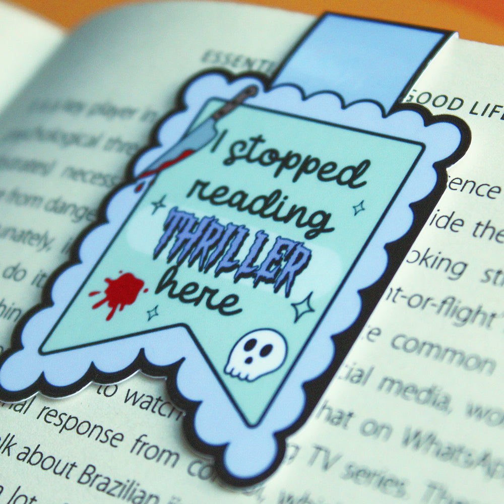 Bookmark with text 'I stopped reading thriller here' on a book page
