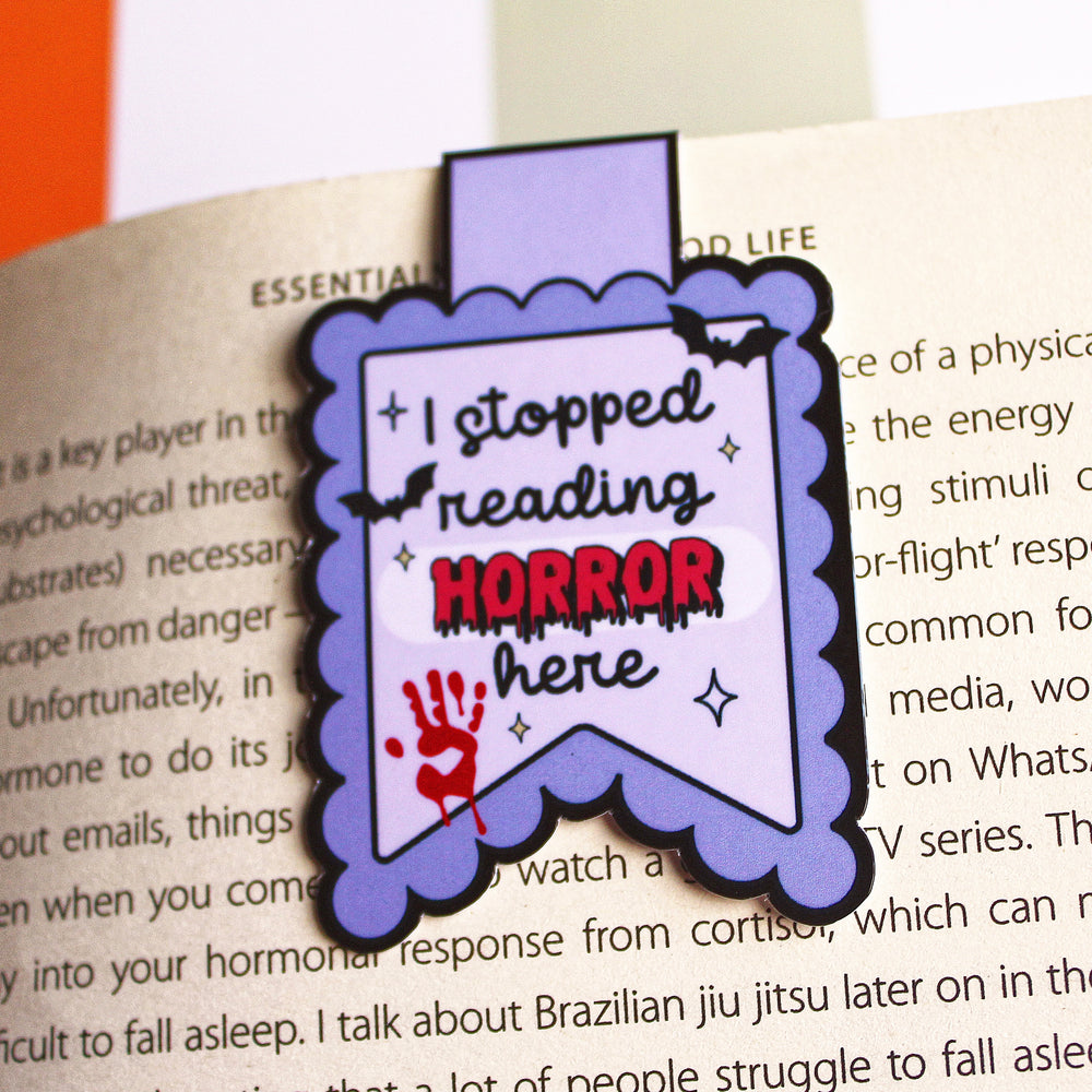 Bookmark with 'I stopped reading horror here' text on an open book