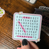 Load image into Gallery viewer, Hand holding a word search sticker with letters on a wooden surface

