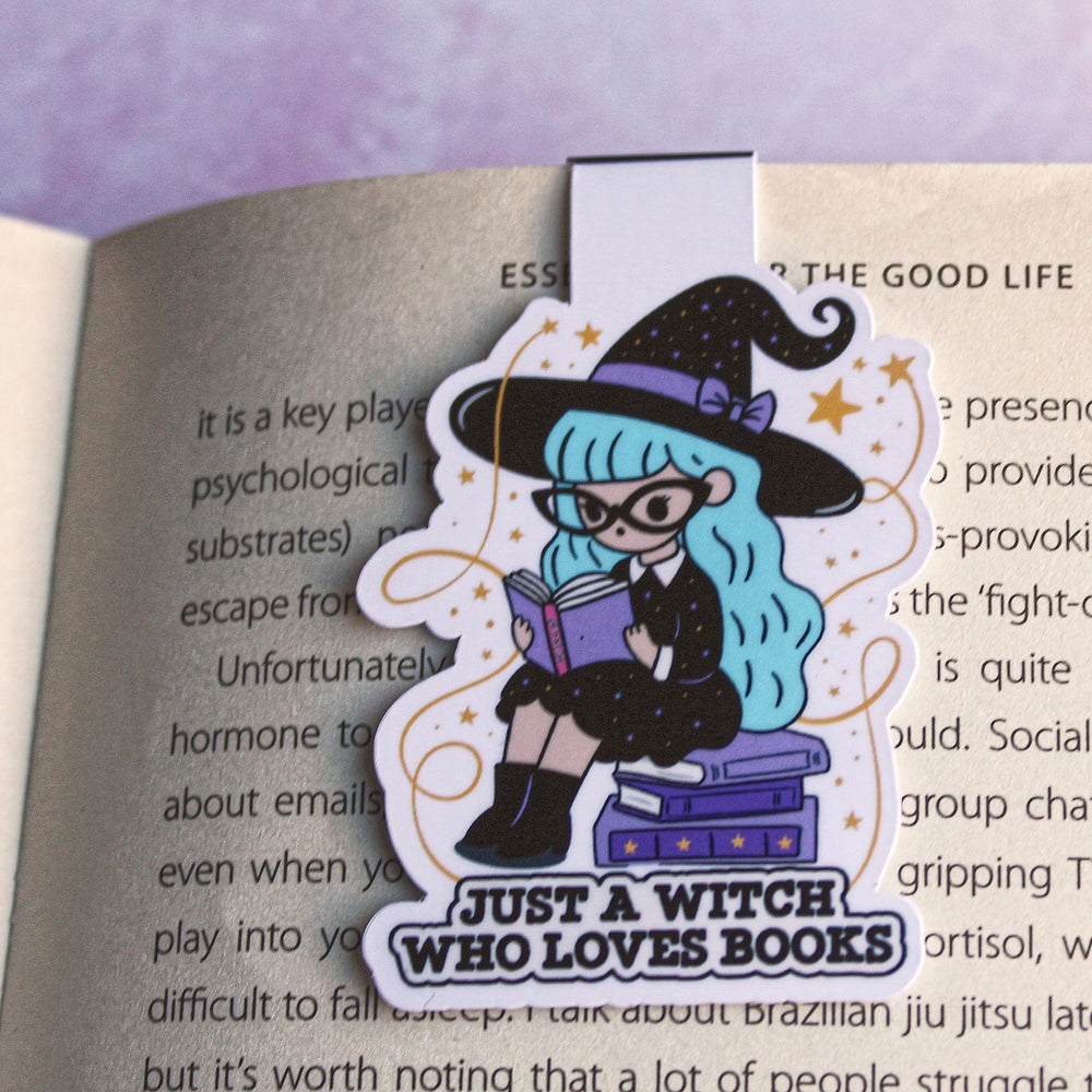 Bookmark with a witch design reading 'Just a Witch Who Loves Books' on an open book.