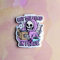 Load image into Gallery viewer, bookmark with a skeleton reading a book and a cup of coffee, text 'Let me read in peace', on a pastel background.
