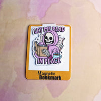 Load image into Gallery viewer, Magnetic bookmark with a skeleton reading a book design on a watercolor background

