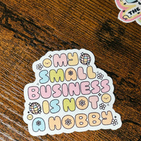 Load image into Gallery viewer, Sticker with 'My small business is not a hobby' text on a wooden surface
