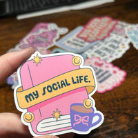 Load image into Gallery viewer, Sticker with 'my social life' text held by a hand on a wooden surface
