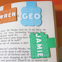 Load image into Gallery viewer, Book with colorful bookmarks labeled 'Wren', 'Geo', and 'Jamie' on a book page.
