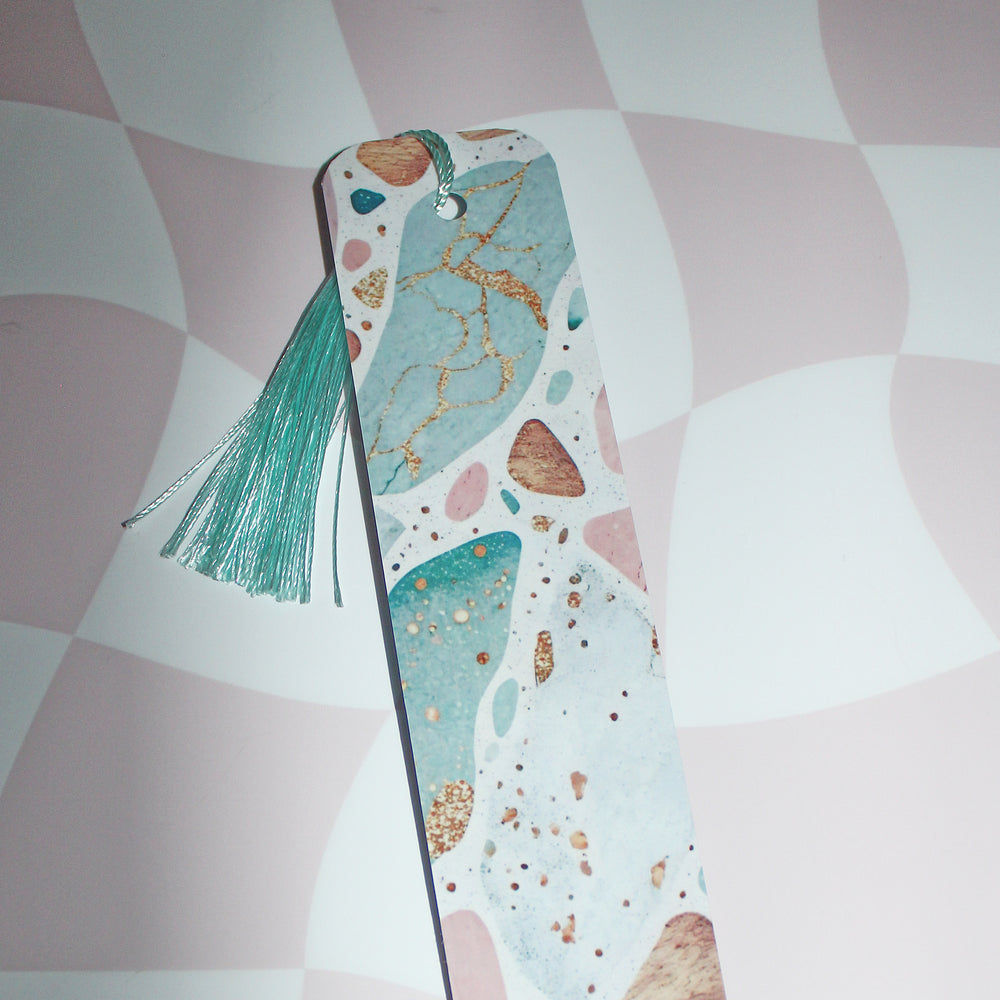 Decorative phone case with a tassel on a pink and white patterned background