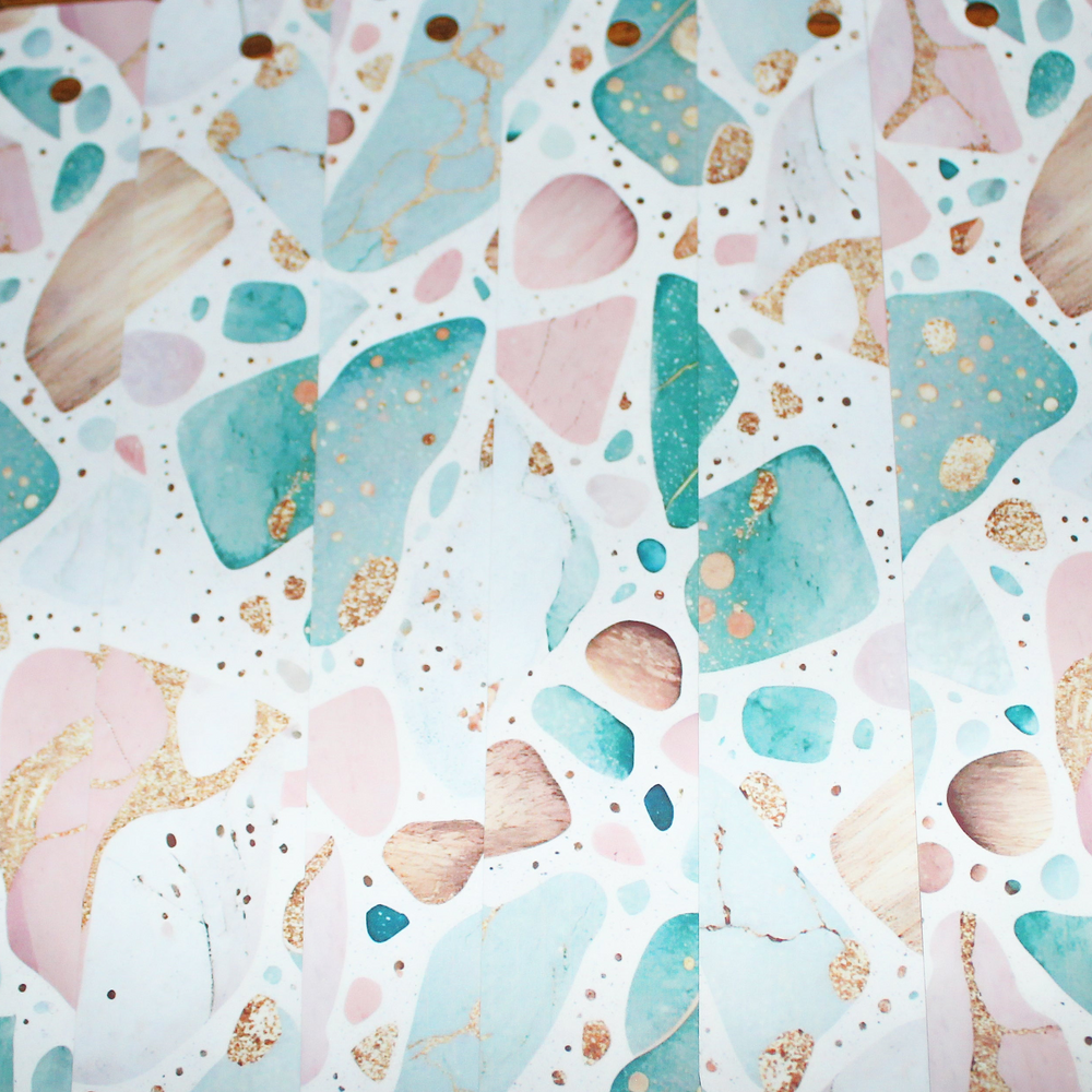Patterned paper with abstract shapes in teal, pink, and gold on a white background
