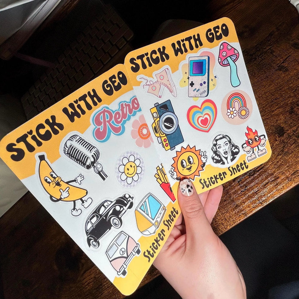 Sticker sheet with various retro-themed stickers held by a hand on a wooden surface.