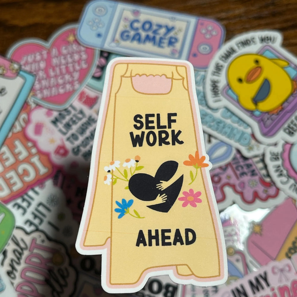 Sticker with 'Self Work Ahead' text on a colorful background of other stickers.