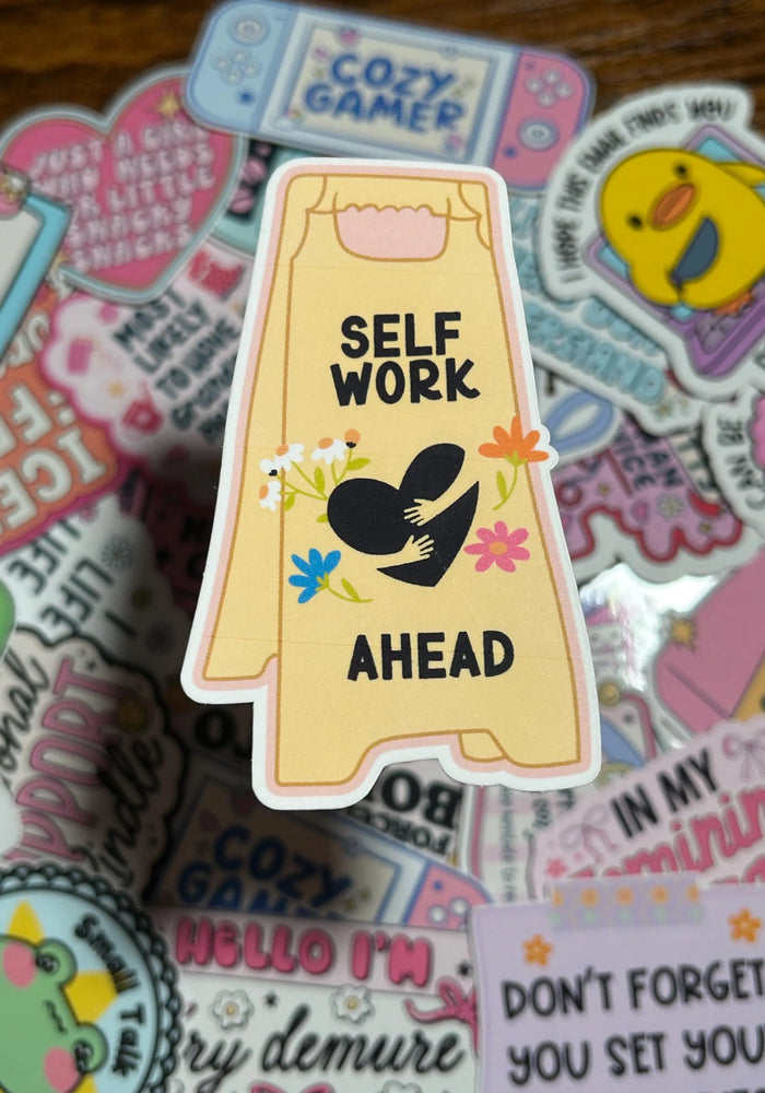 Sticker with 'Self Work Ahead' text on a colorful background of other stickers.