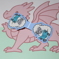 Load image into Gallery viewer, Cartoon dragon with sunglasses featuring sheep reading a book . on a light green background
