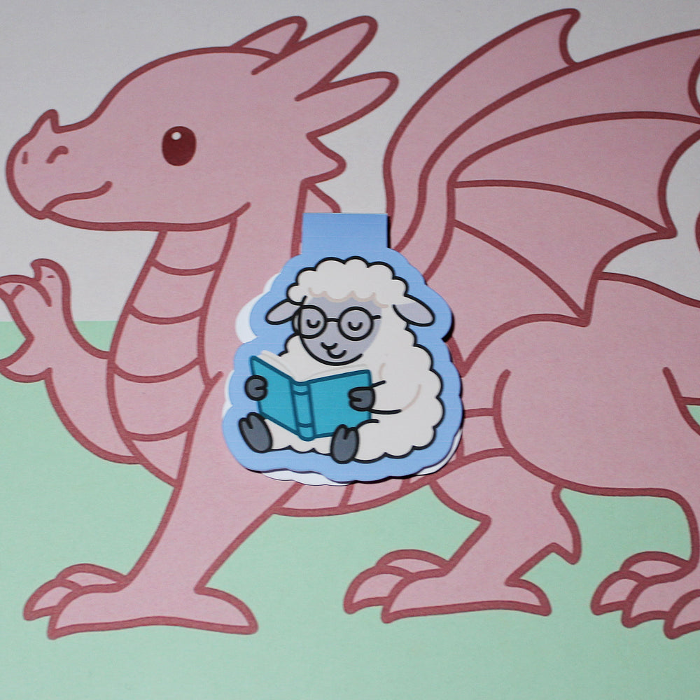 bookmark of a sheep reading a book on a light green background