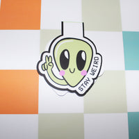 Load image into Gallery viewer, bookmark with an alien design and 'Stay Weird' text on a colourful checkered background
