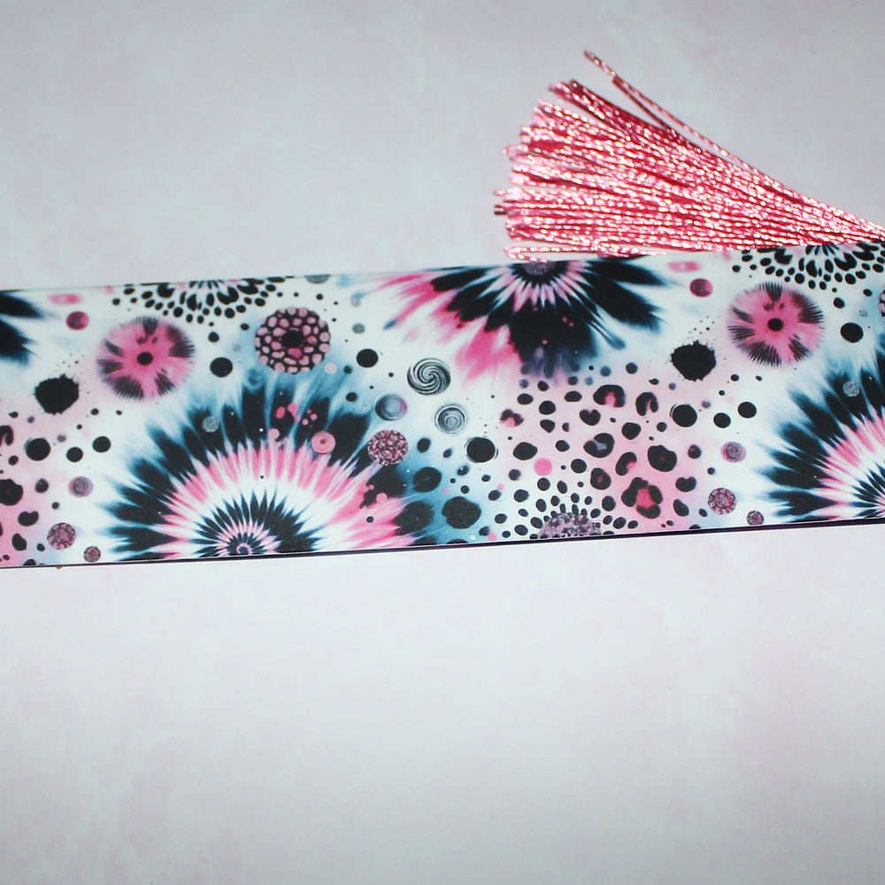 bookmark with tie-dye pattern and pink tassel on a light grey background