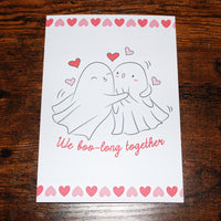 Load image into Gallery viewer, Card with ghost couple illustration and 'We boo-long together' text on a wooden surface
