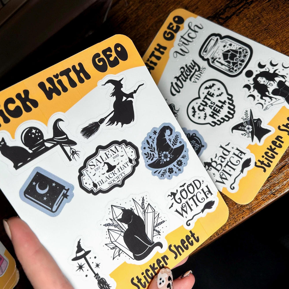 Two sticker sheets with witch-themed designs on a wooden surface.