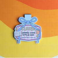 Load image into Gallery viewer, Decorative magnetic bookmark with text 'CLOSED: Currently booked &amp; cozy at home' on a colourful background

