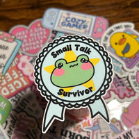Load image into Gallery viewer, Small Talk Survivor Sticker | Funny Frog Sticker | Introvert Humor | Mental Health Positive Quote | Gloss Vinyl | Stick With Geo
