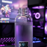 Load image into Gallery viewer, A clear glass water bottle with a white sticker, filled with water and sitting on a wooden desk with a blurred gaming setup in the background.
