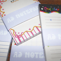 Load image into Gallery viewer, Small notepads with colorful designs and text on a wooden surface
