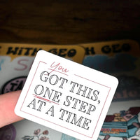 Load image into Gallery viewer, Card with motivational text 'You got this, one step at a time' held over a colorful background.
